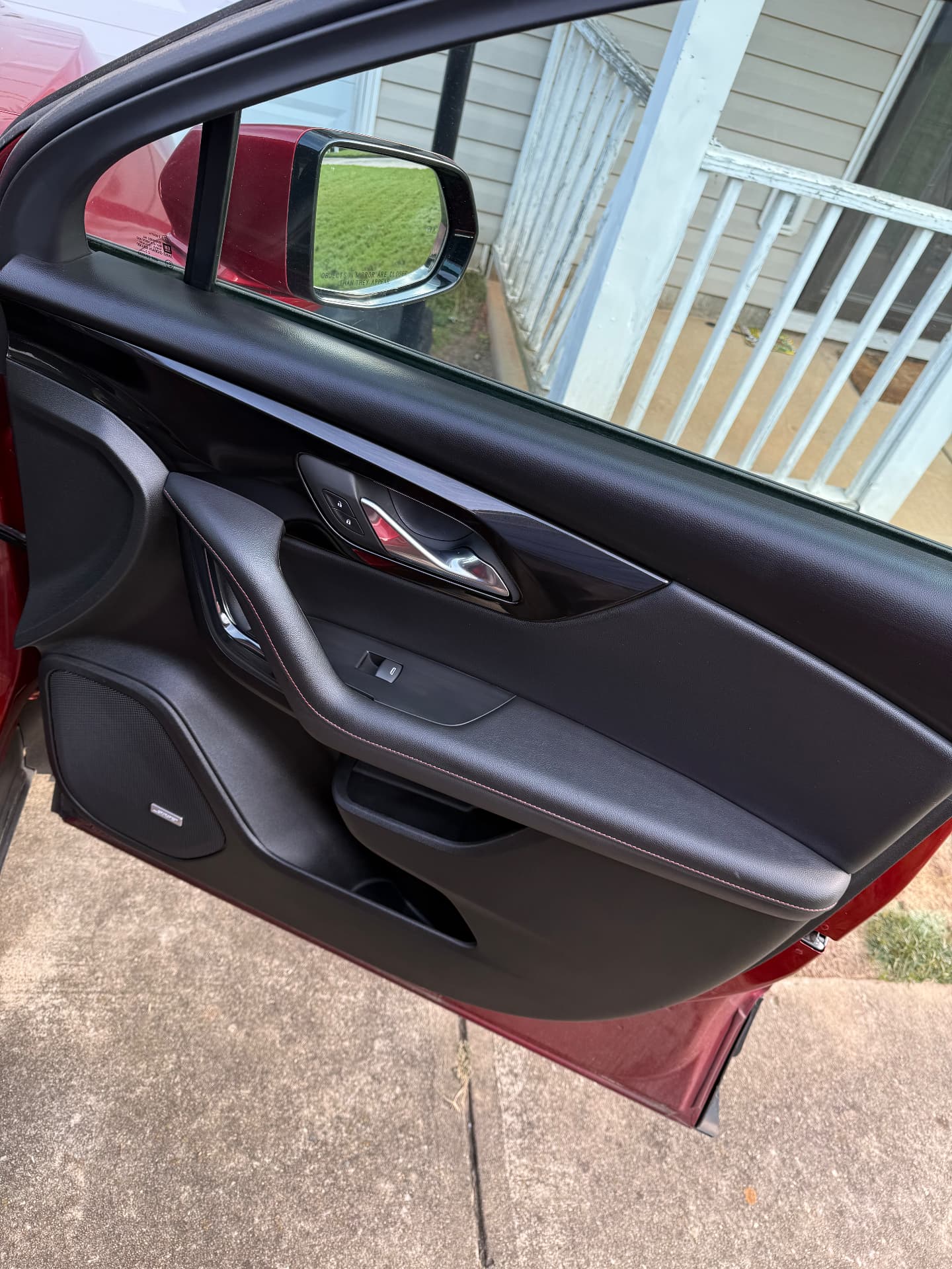 Cleaned and conditioned black leather door panel on a red vehicle after leather care